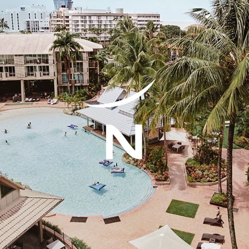 Pool surrounded by coconut trees in Novotel Cairns Oasis
