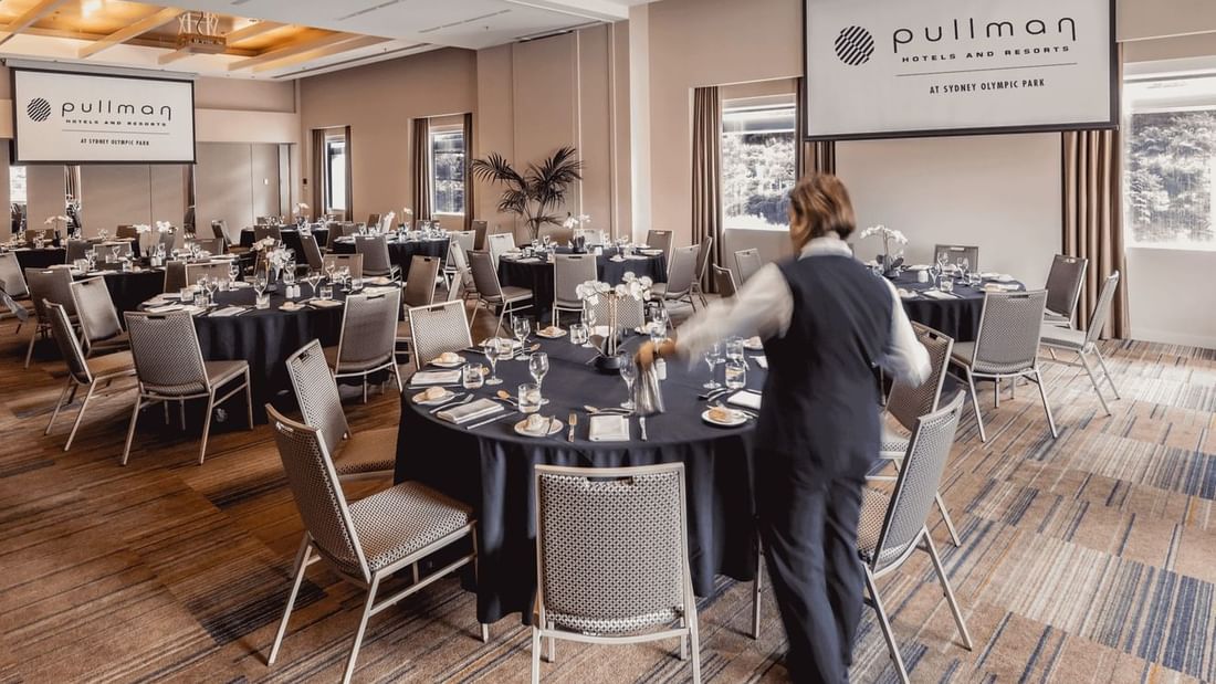 Banquet tables arranged in Nexus 1 & 2 with carpeted floors and outdoor views at Pullman Sydney Olympic Park