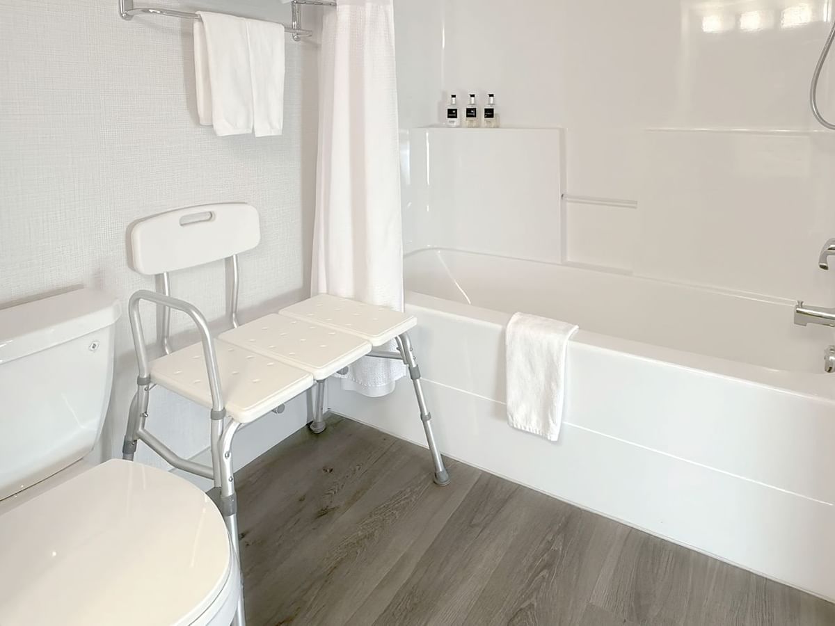 Accessible washroom with toilet, bathtub, soap, and towel