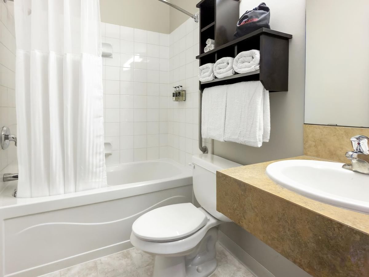 Hotel bathroom with a bathtub, toilet, and sink.