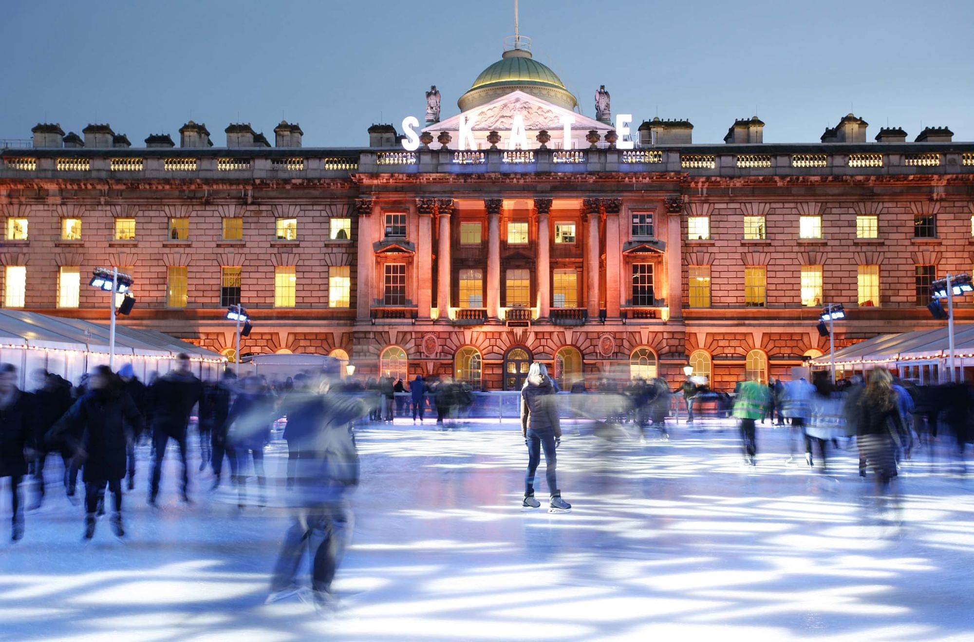 People ice-skating at night in front of Somerset House near Warwick Hotels and Resorts