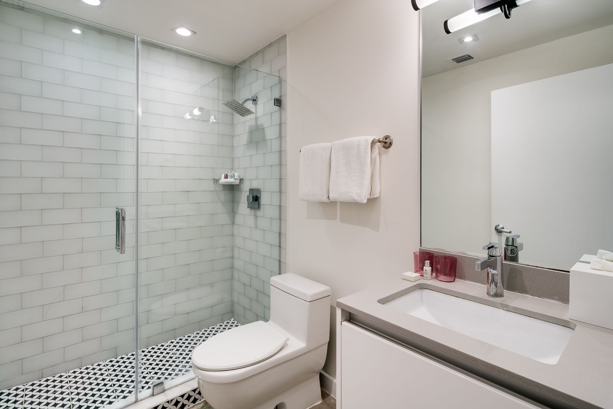 A clean bathroom with a shower, toilet, and sink