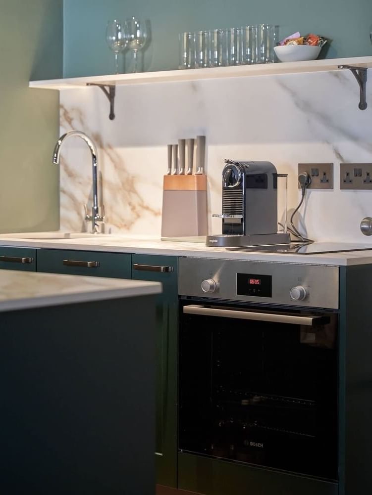 Modern kitchen with appliances and marble countertops in Two Bedroom Apartment at The Capital Hotel