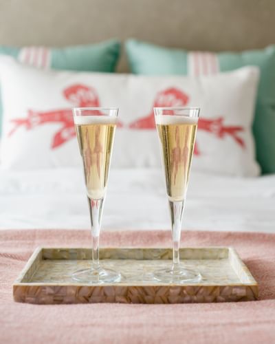 Champaign glasses placed on the bed in a Room at Catalina Island Company