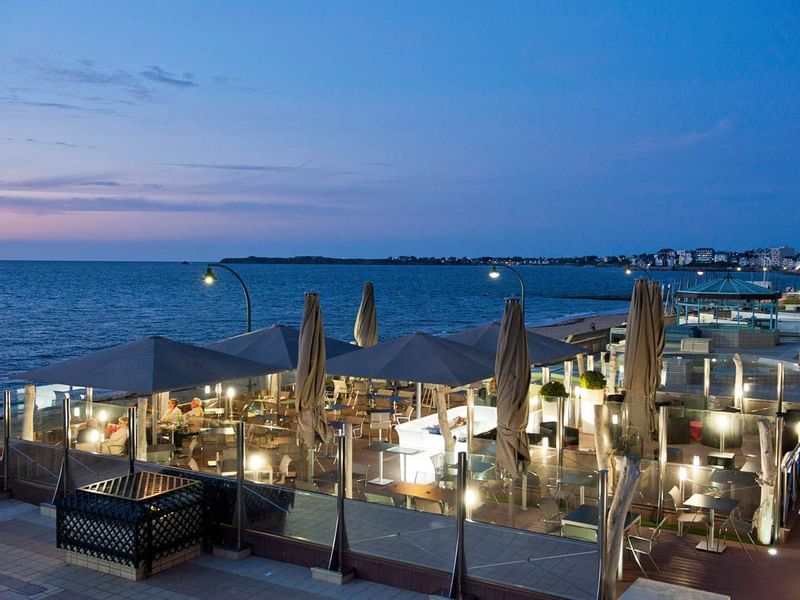 Terrace with night sea view at Le Grand Hôtel des Thermes
