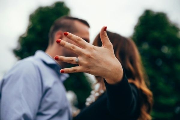 A new fiancée displaying her engagement ring on her hand.