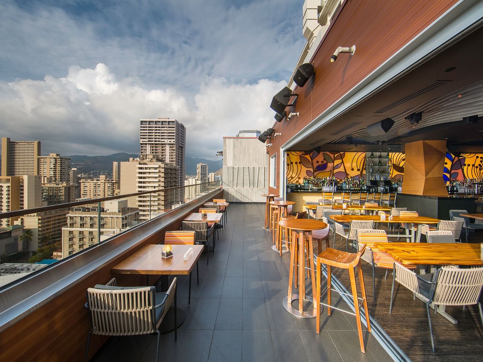 Dining tables arranged on the rooftop in Sky Waikiki at Waikiki Resort Hotel by Sono