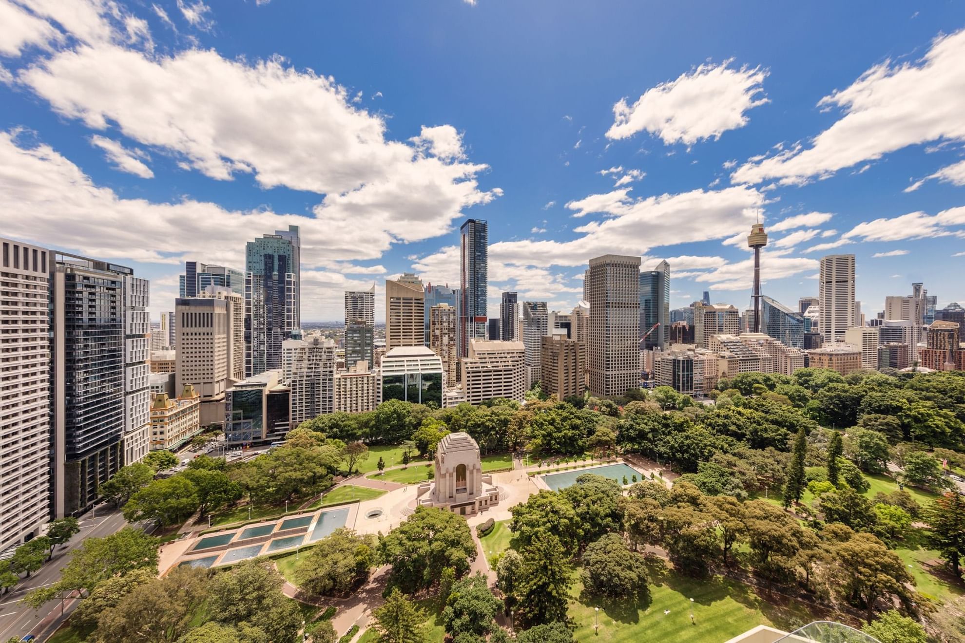 Aerial view of the city with lush greenery under cloudy sky near Pullman Sydney Hyde Park