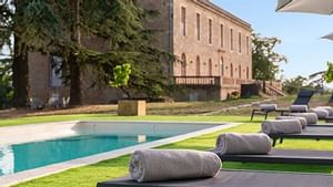 Towels on sunbeds by the outdoor pool at Originals Hotels