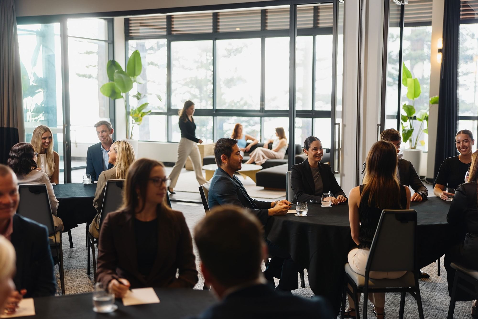 Meeting room at Elysium Manly featuring business delegates at round tables, showcasing Manly conference venues