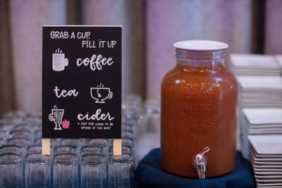 A closeup jug and glass with notice at The Venue at Portwalk