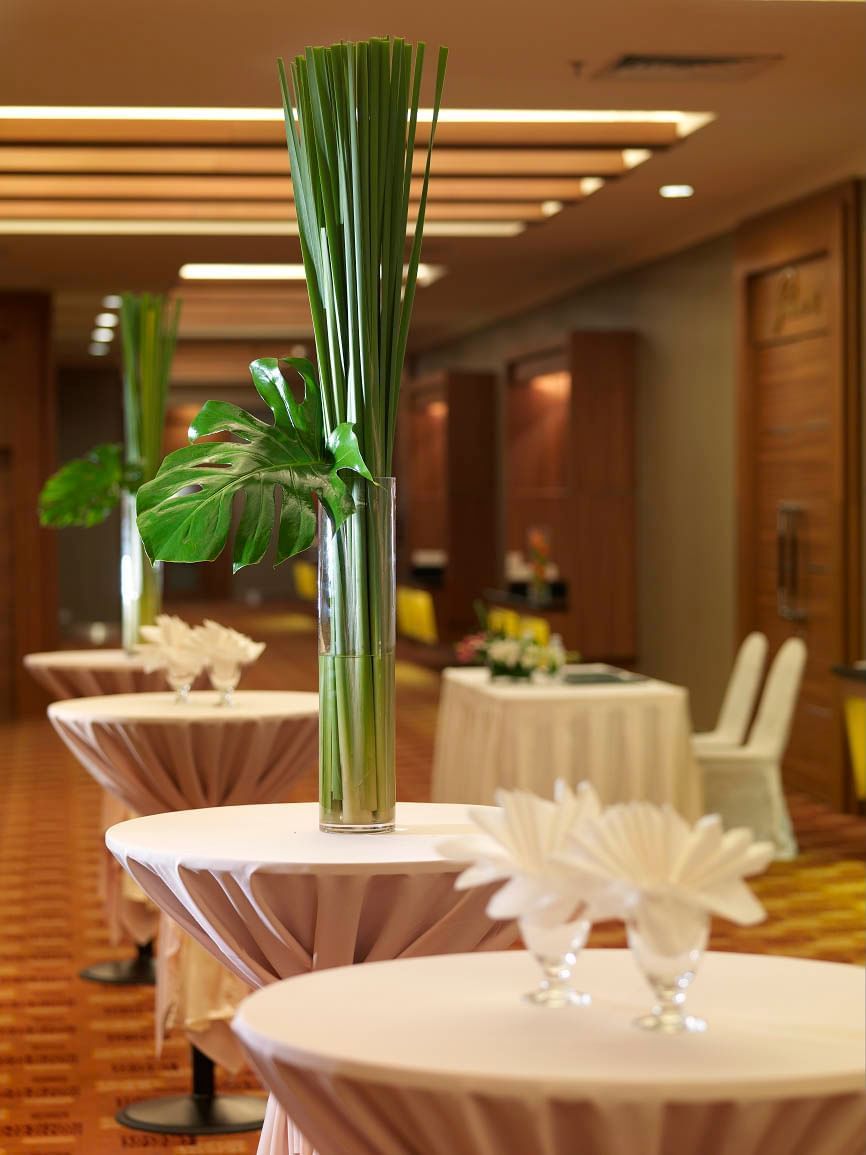 A vase with a long green stem flower on a white clothed table in Perdana foyer at Cititel Penang Hotel