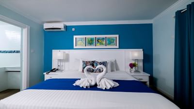 Cozy bed with side tables and air conditioner in Studio Garden Pool View at Dover Beach Hotel