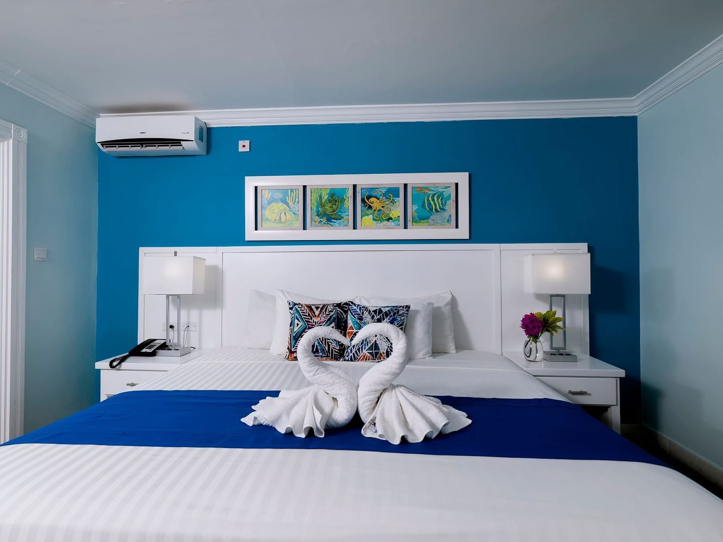 Cozy bed with side tables and air conditioner in Studio Garden Pool View at Dover Beach Hotel
