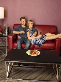 Couple lounging on a sofa while enjoying a glass of wine at Cove Pocono Resorts