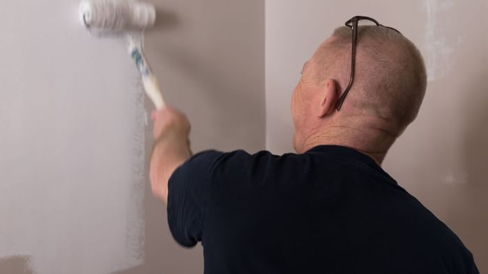 A man color washing a wall in white at Hotel Cassitel