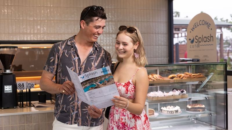 Couple looking at the menu in Splash Cafe at Novotel Darwin Airport