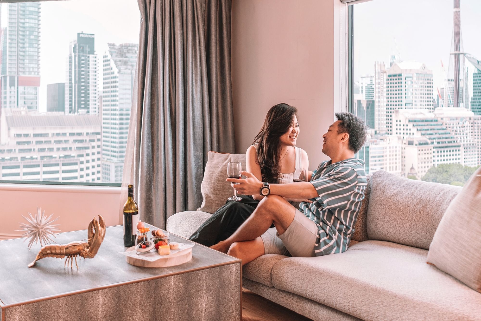 Couple enjoying wine together with a city view at Pullman Sydney Hyde Park