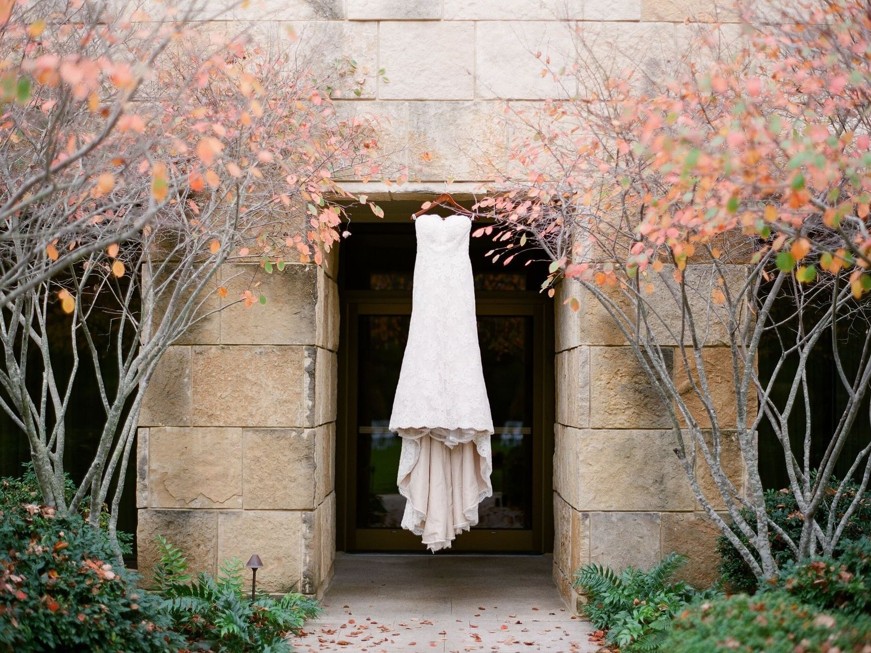 White wedding dress hanging in front of the entrance at Umstead Hotel and Spa