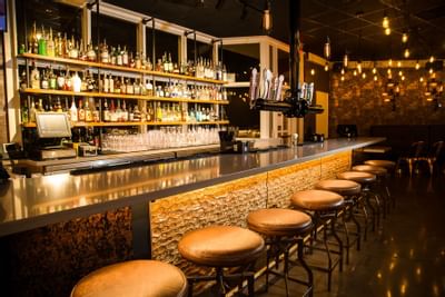 Stools line a bar area in Nine Flags Bar & Grill at The Fredonia Hotel