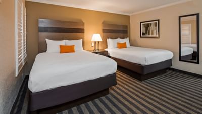 two beds and pillows in a hotel room
