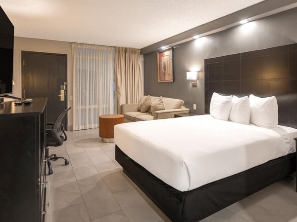 Accessible room with a queen bed, modern decor, and a seating area.
