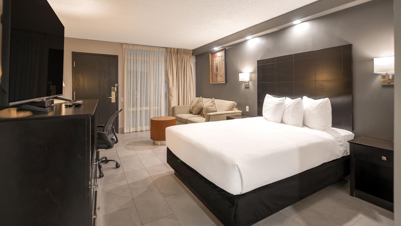 Accessible room with a queen bed, modern decor, and a seating area.