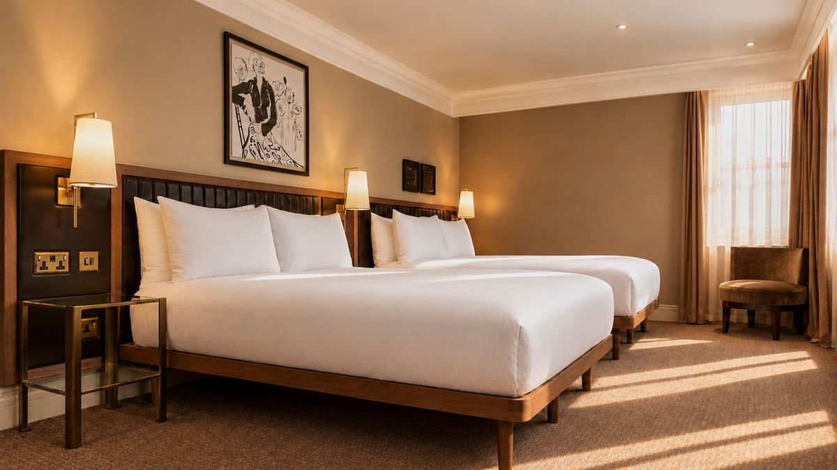 Spacious Family Room with two double beds, warm lighting, and modern artwork at The May Fair Hotel, London.
