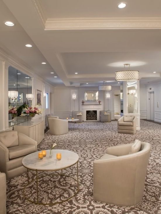 Living room in the Pre-Function room featuring plush armchairs and patterned carpet with warm fireplace at Warwick New York