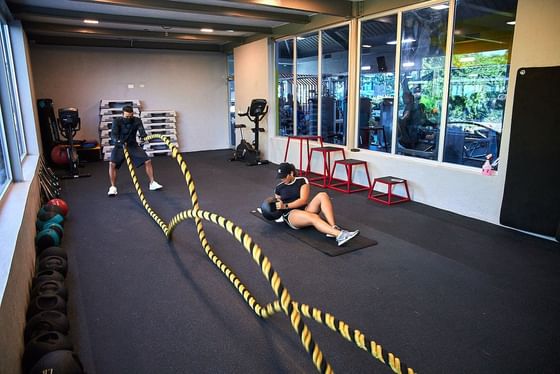 A woman exercising in a fitness center at Cha Cha Hotel