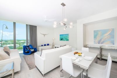 Dining table by the living area with white furniture and ocean views in N703 Room, The Residences at Seafire