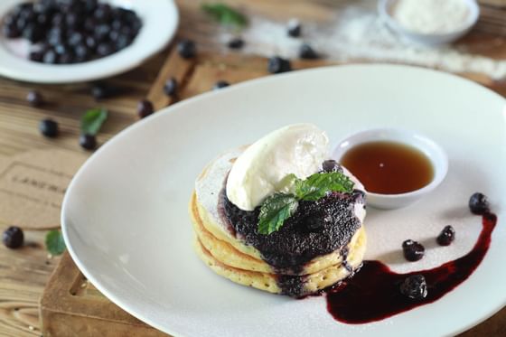 Pancakes topped with blueberry compote, whipped cream, and mint at Peppers Seminyak