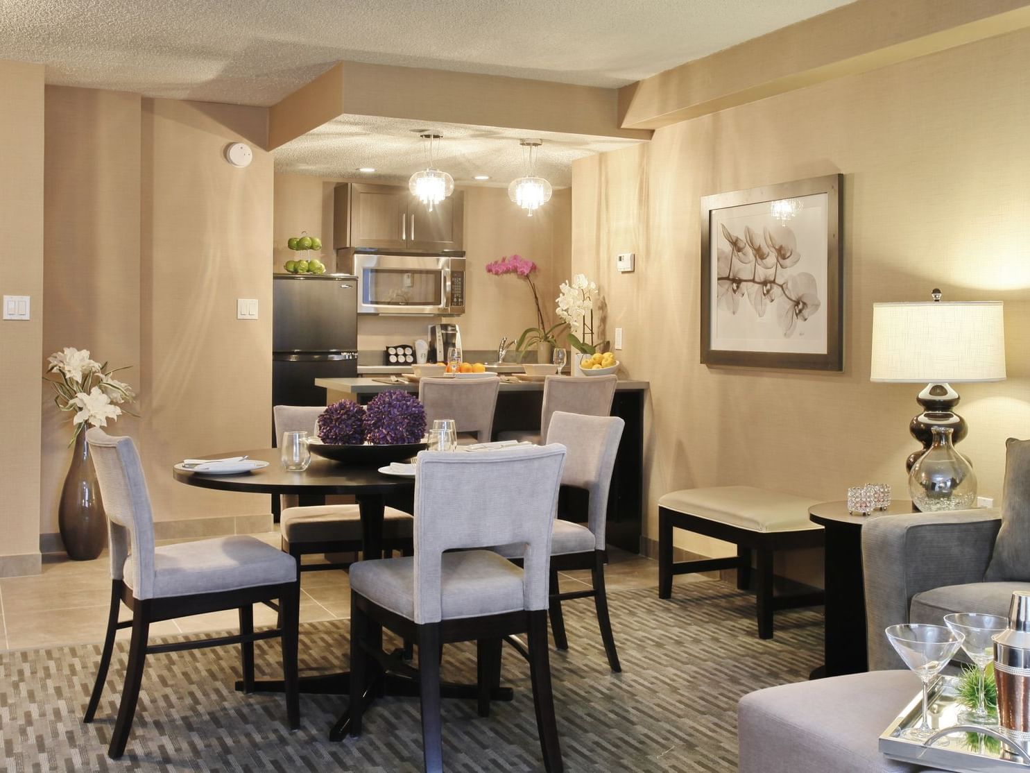 a dining table next to a kitchen in a hotel suite