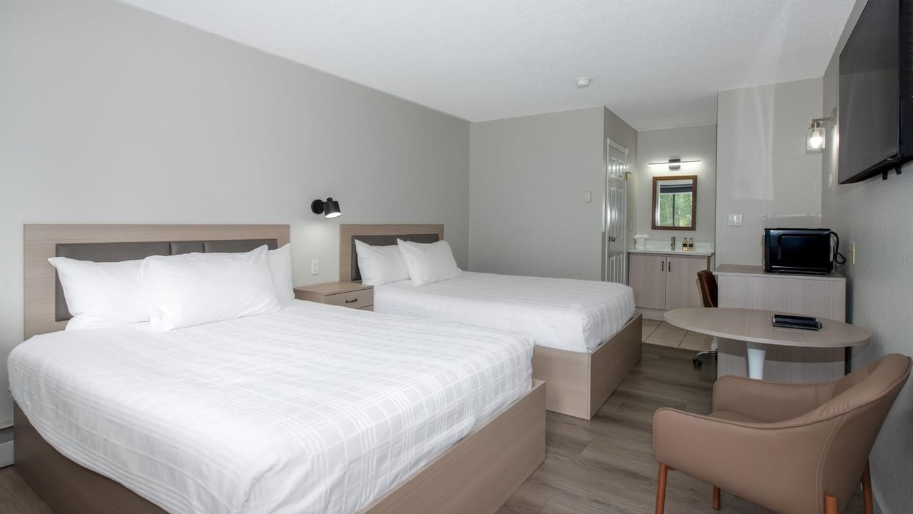 Guest room at Coast Red Deer Hotel with two queen beds and seating area