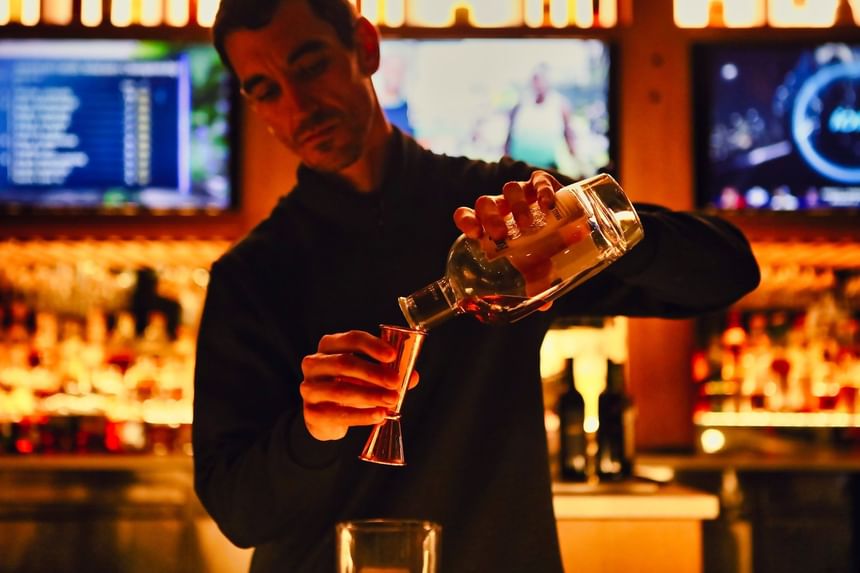 Bartender making drinks by the counter in Trade Restaurant & Lounge at Hotel Republic San Diego