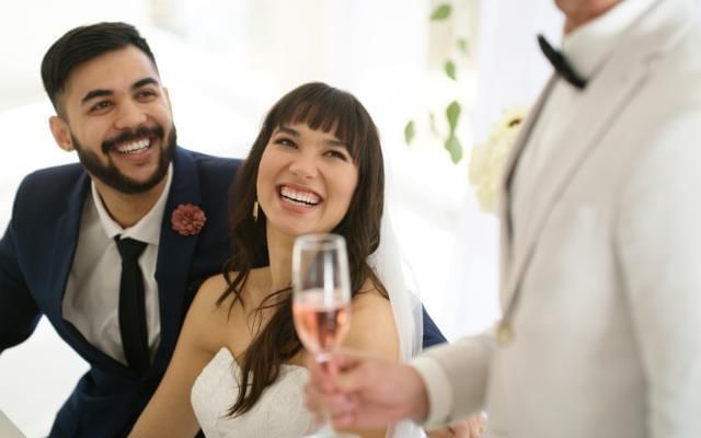 man giving best mans speech with bride and groom laughing