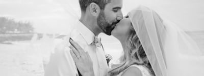 Wedding couple kissing by the beach near Bougainvillea Barbados