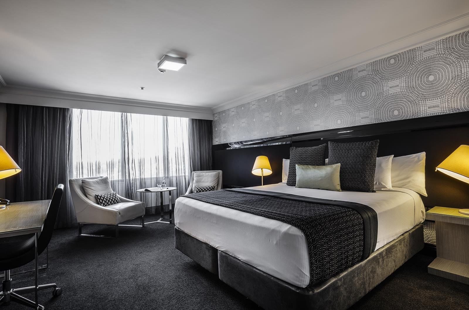 Luxury bed room with a chair  at Pullman & Mercure Brisbane King