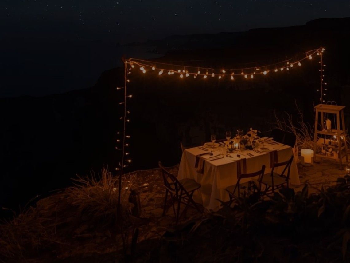 Intimate outdoor dining table set with string lights under a starry night sky at Royal Isabela in Isabela.