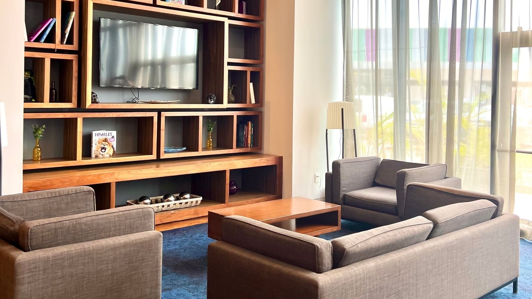 Lounge with grey couches & a wooden table, by a window, images of Cancun, Mexico hotels at Fiesta Inn Express Cancún Cumbres