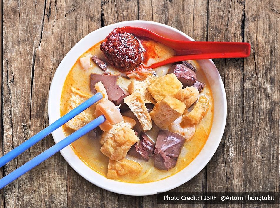 Penang curry mee is a hawker noodle dish with coconut milk curry gravy, egg noodle, pig's blood cube, shrimp, tofu puffs, & sambal