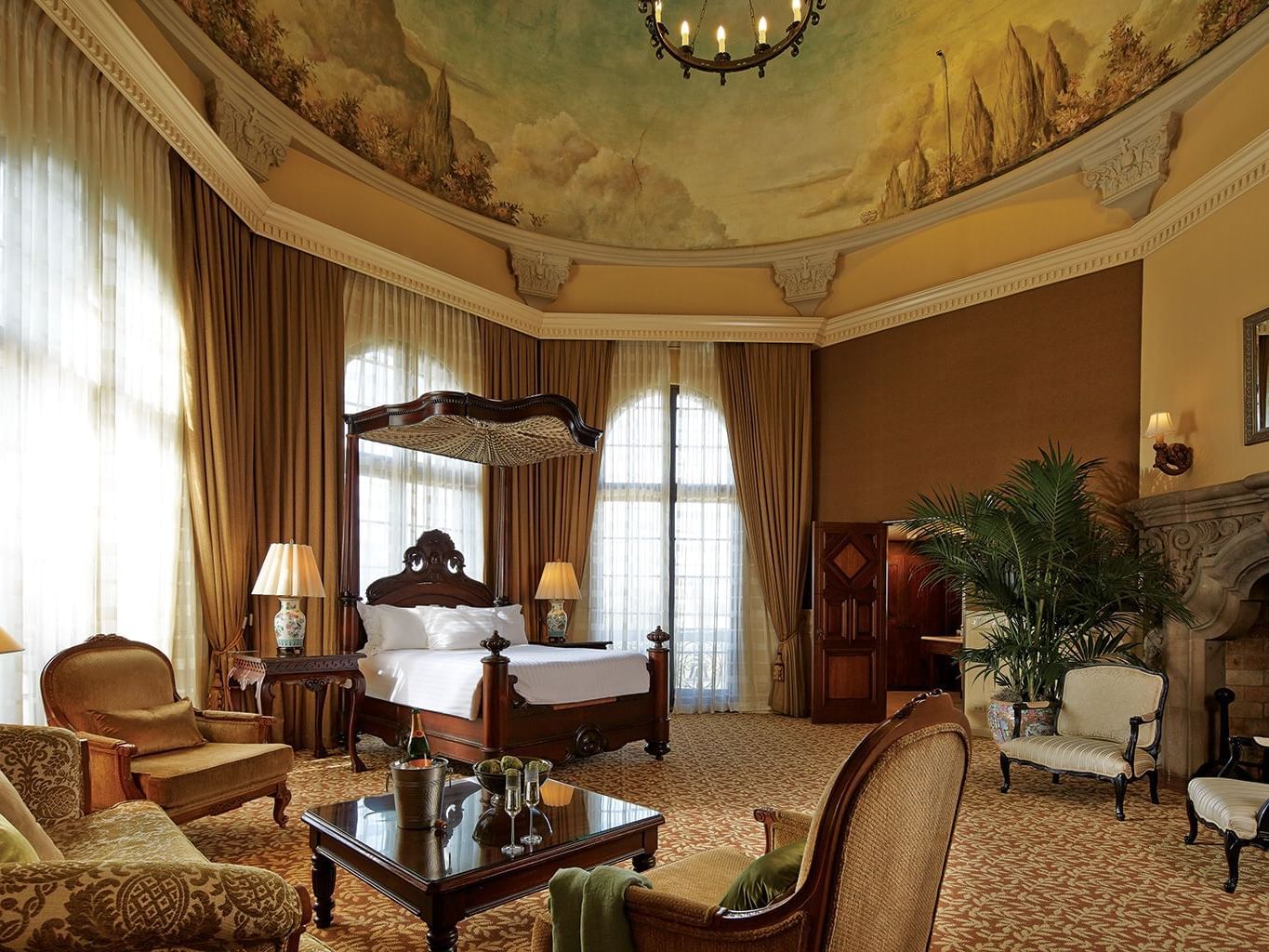 large circular room with canopy bed, seating area and fireplace