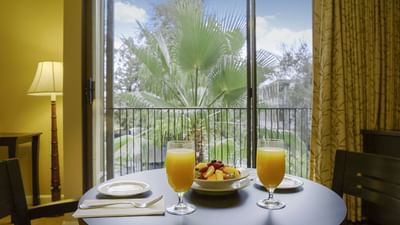 two glasses of orange juice on round table with window and trees