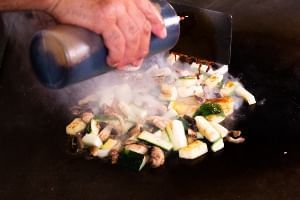 A chef at Shogun Japanese Steakhouse pours sauce over a vegetarian, plant-based dish at the Orlando restaurant.