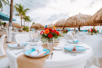 Close-up of beachside dining table arrangement with flower vase at Passions on the Beach