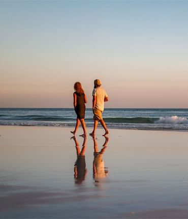 A couple walking by the private beach near Falmouth Tides