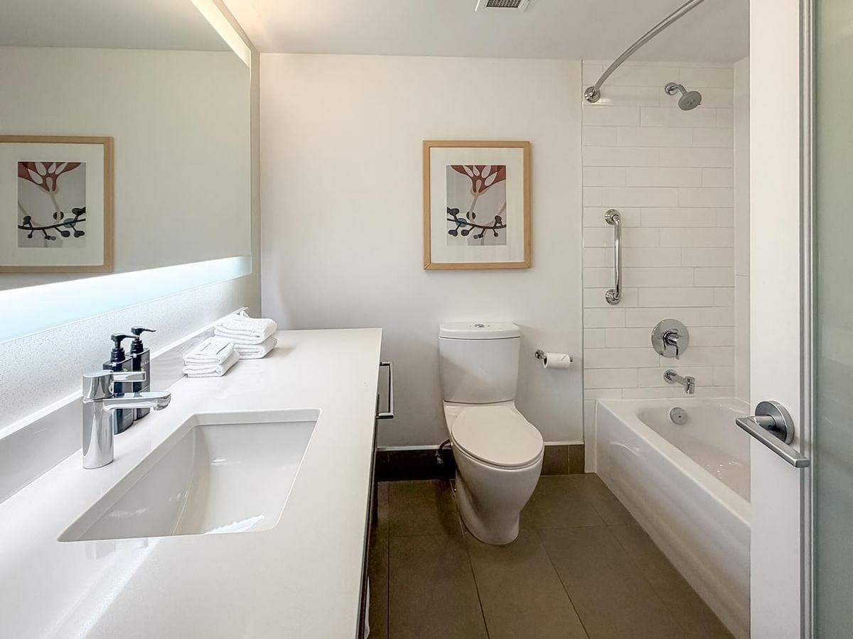Clean, modern bathroom with a bathtub and separate toilet at Coast Bastion Hotel in Nanaimo.