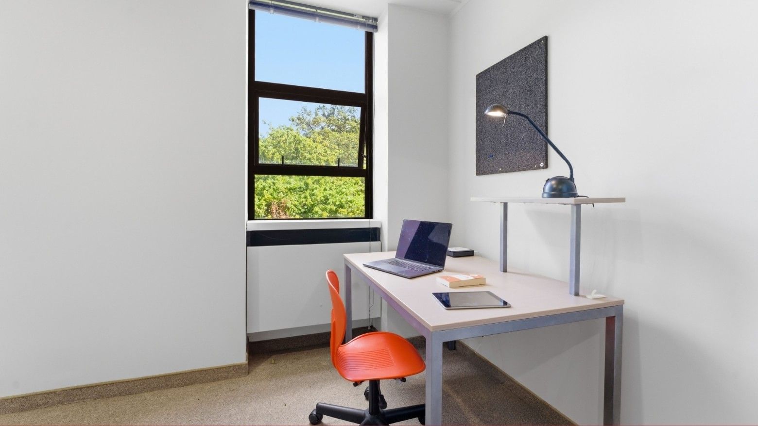 Office desk with laptop, tablet, and lamp by a window at UniLodge Stafford House.