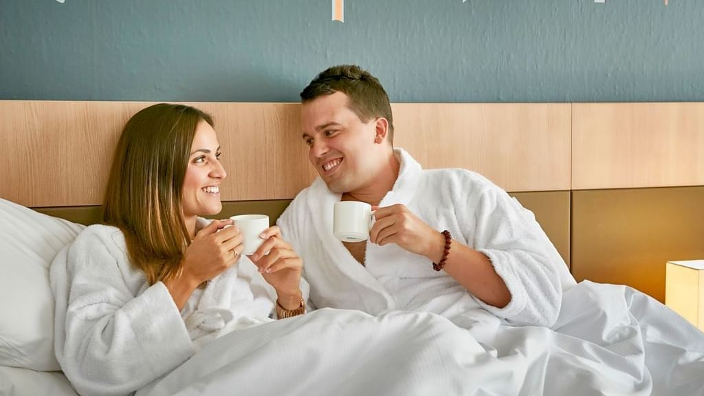 Couple in bathrobes and having tea at Novotel Darwin Airport