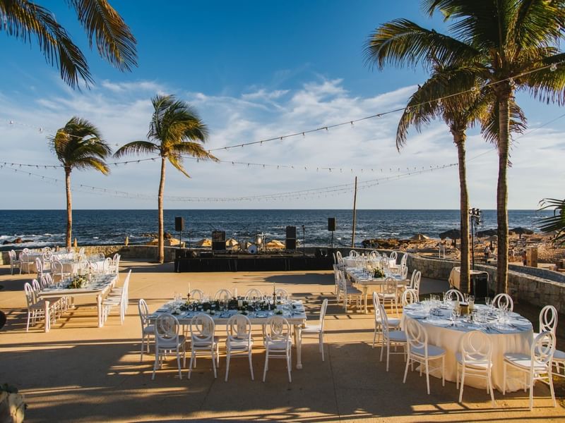 Beachside event setup with tables in overlooking the ocean near Grand Fiesta Americana